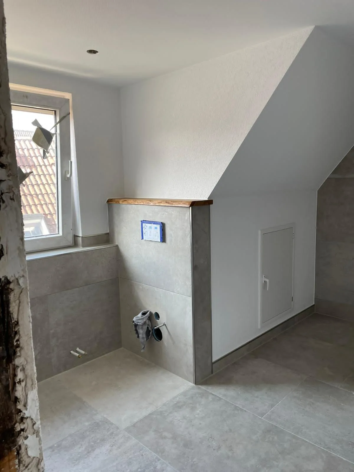 Badezimmer unter der Dachschräge mit großformatigen Fliesen