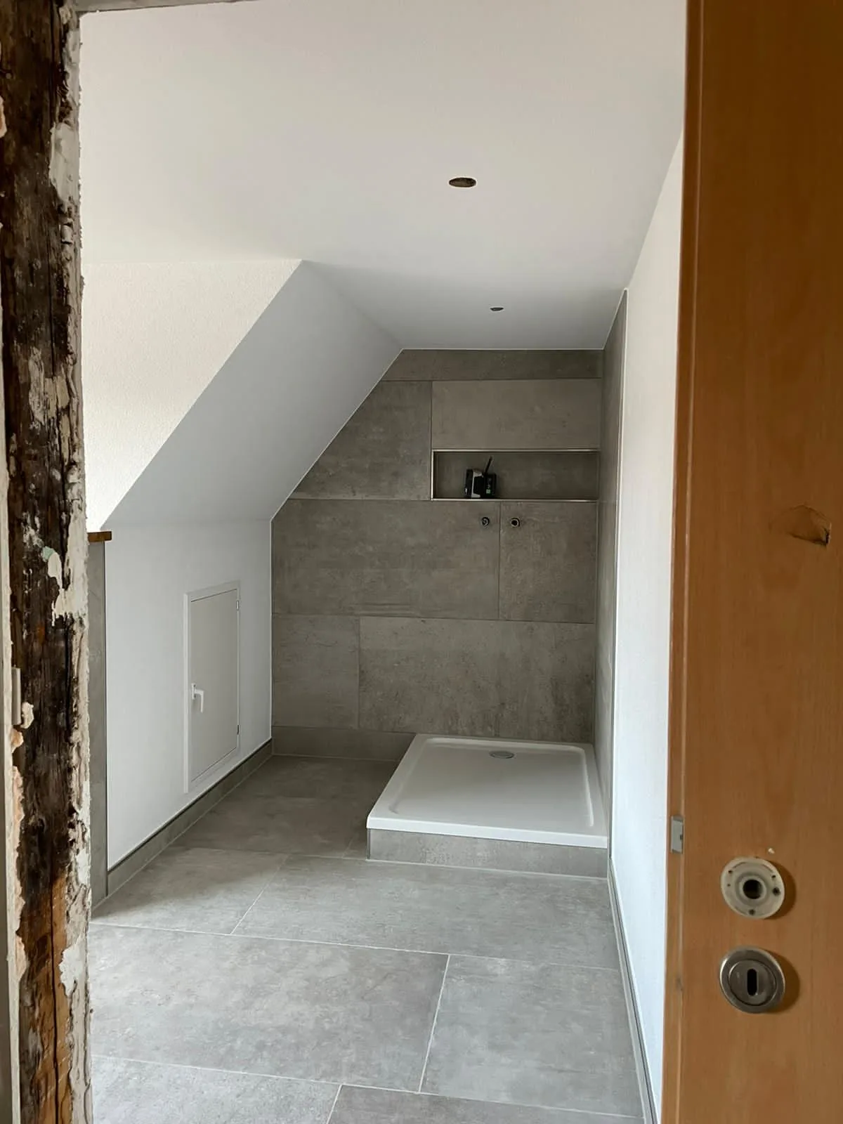 Gefliestes Bad unter der Dachschräge mit Dusche