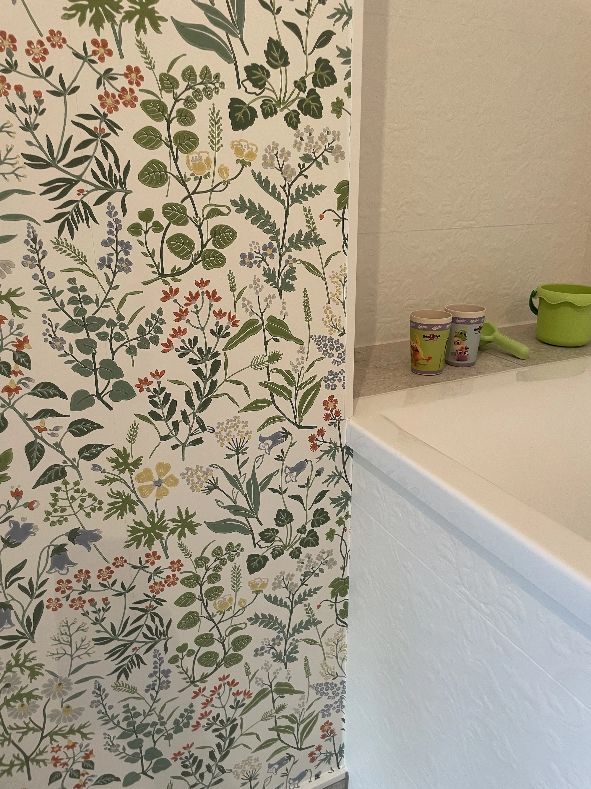 Badewanne vor Wandfliesen mit Pflanzenmuster