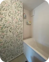 Badewanne vor Wandfliesen mit Pflanzenmuster