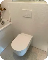 Wand-WC vor weißen Strukturfliesen