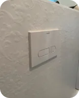 Weiße Strukturfliesen mit WC-Drückerplatte